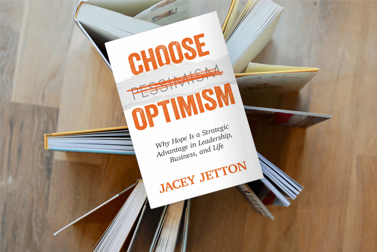Choose Optimism by Jacey Jetton — book cover resting on a fan of open books